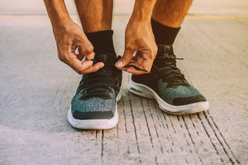 Men are tying up their feet. Before going to jogging,Men are binding shoes