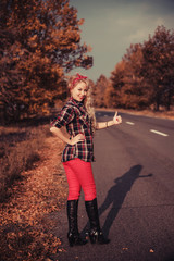Fototapeta premium Beautiful woman in pin up style posing on the road.