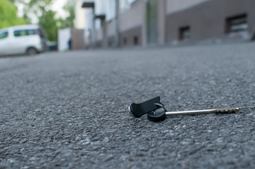 The lost bunch of keys, lies on the asphalted sidewalk of the road, near the entrance of an apartment building in the city