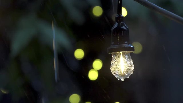 Garlands of lamps on a stand on the street. Light outdoor Bokeh Light bulb decor in outdoor party. Decorative outdoor string lights hanging on tree in the garden at day time.