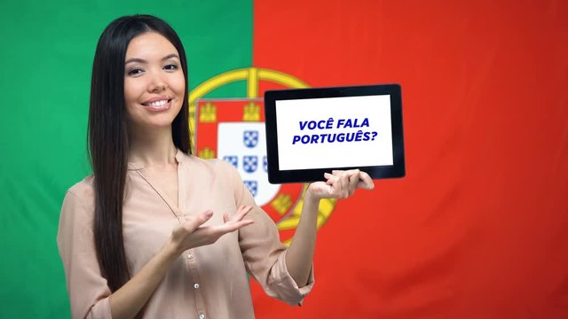 Woman holding tablet with do you speak portuguese phrase, app learning language
