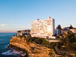 Fototapeta na wymiar Tall white apartment building at the coastline cliff side.