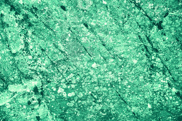 Vintage green background. Rough painted wall of emerald color. Imperfect plane of virid colored. Uneven old decorative toned backdrop of green tint. Texture of emerald hue. Ornamental stony surface.