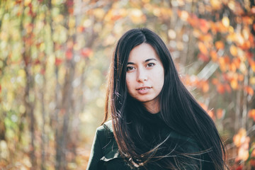 Female beauty portrait surrounded by vivid foliage. Dreamy beautiful girl with long natural black...