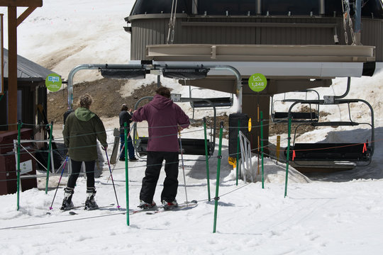 Skiers Riding A Ski Lift Up The Mountain