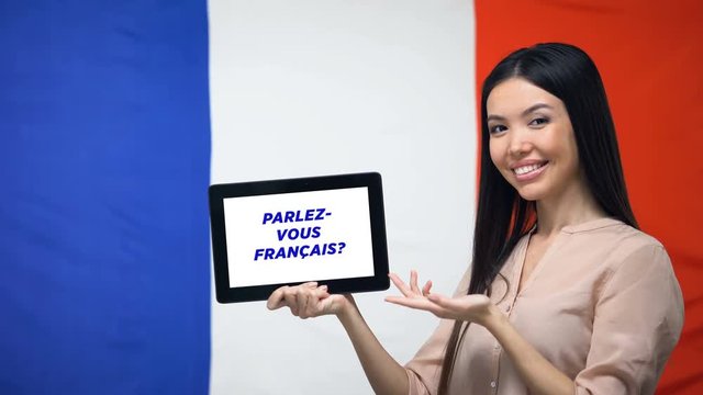 Woman holding tablet with do you speak french phrase, app for learning language