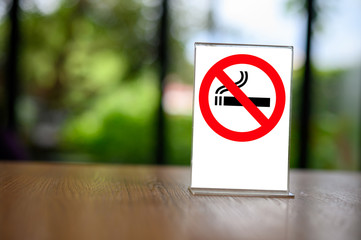 no smoking sign with shopping place background on wooden table