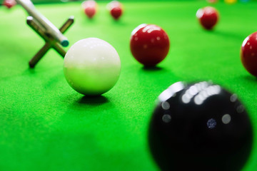Playing snooker, piercing the red ball, black, aiming the ball and pocketing the hole to score points.