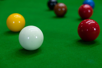 Playing snooker, piercing the red ball, black, aiming the ball and pocketing the hole to score points.