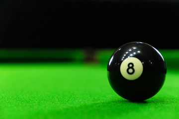 Close-up photos of billiard ball, number 8 and green floor