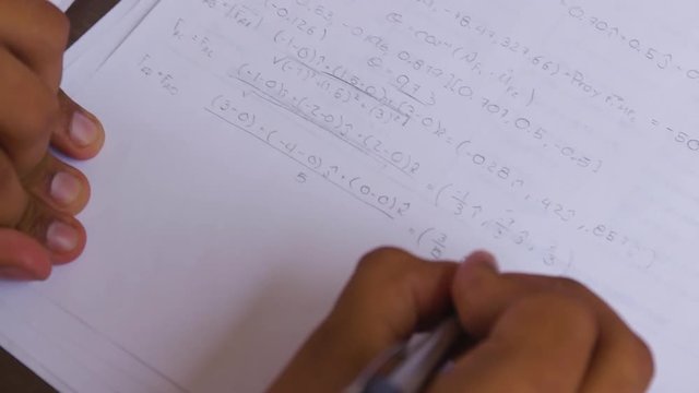 Student writing math formula by hand