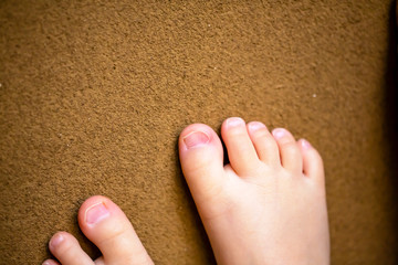 土壁に置いた子供の足先