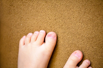 土壁に置いた子供の足先