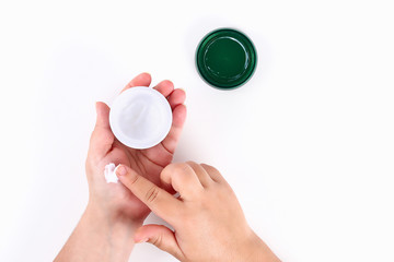 Girl uses hand cream on white background. Top view.