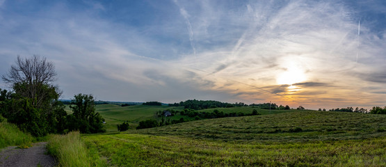 Fototapeta na wymiar Panorama with freshly mowed hay field at sunset