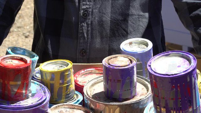 Leftovers of latex and oil based paints with empty metal paint cans