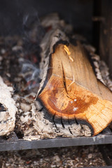 Firewood, carbon and ash in fireplace or smokehouse