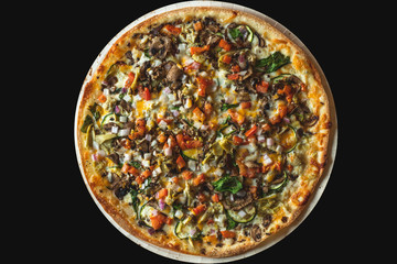 Vegetarian Pizza with Tomatoes, Spinach, Paprika, Onion, Basil, and Cheese. Top View with Black Background