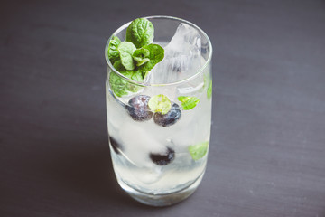 Blueberry mojito cocktail on the wooden background. Selective focus. Shallow depth of field.