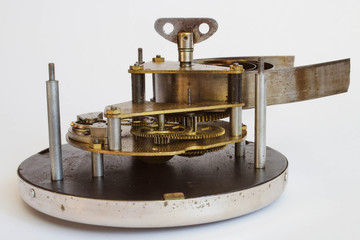 Broken old metallic clockwork mechanism on white background