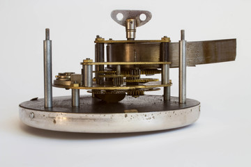 Broken old metallic clockwork mechanism on white background