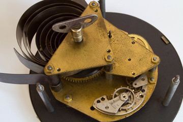 Broken old metallic clockwork mechanism on white background