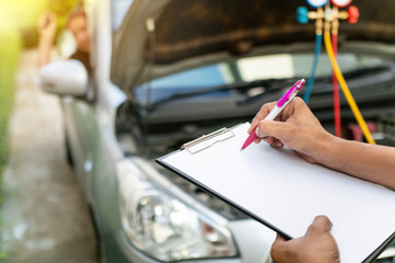 Auto mechanic perform vehicle checkup while service advisor take notes,Professional Auto Service Technician .