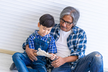 Builder Grand Father is putting on working glove for his grandson for family generation concept
