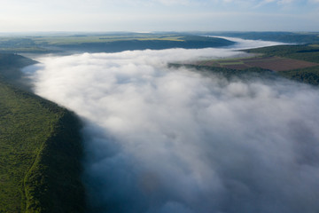 Canyon river in fog shooting from the air