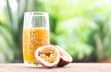 Glass of passion fruit juice wood table with green nature background, food healthy concept, selective focus