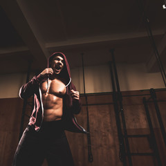Fototapeta na wymiar Strong muscular fighter training hard in modern gym