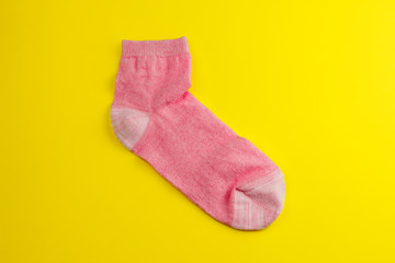 top view  one pink sock on a yellow background