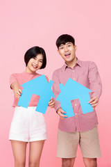 Young couple holding symbols of house
