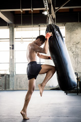 Boxers are training their knees with punching bag.