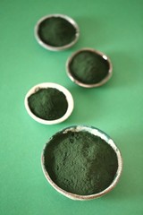 Spirulina algae. green spirulina algae in round cups on a green background.Super food concept.nutritional supplement.