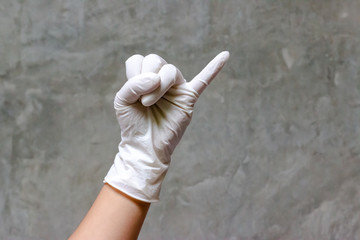 Hand wearing rubber gloves with Pinky finger or little finger symbol. A gesture showing many...