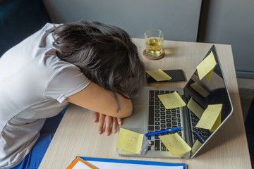 Fototapeta na wymiar Stressful freelancer female fall asleep on laptop with sticky notes
