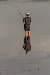 Fisherman and Reflection in the River at Sunset