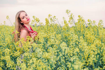 beautiful boho girl posing on camera in canola field