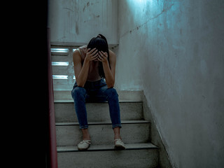 Unhappy depressed teenager with face in hands sitting stair, thinking about problem with...