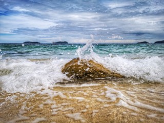Closeup with the sandy beach splashing water and swash wave in Kota Kinabalu, Tanjung Aru beach. Sabah, Malaysia.