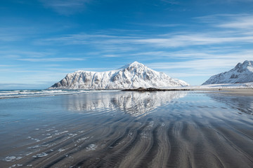 Scenery of furrow beach with snowy mountain on coastline at Skagsanden beach