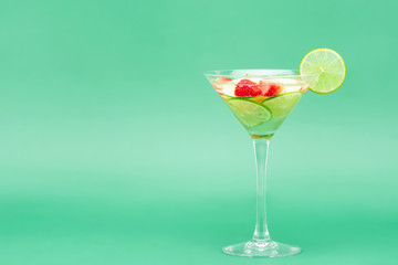 Glass of mixed chilled lemonade in green pastel studio background