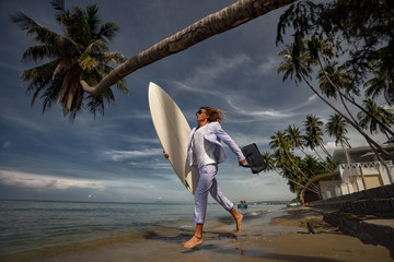 Fashion businessman with surfboard on the beach