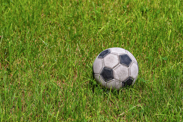 Plakat Old leather soccer ball on green grass with copy space, football sport concept