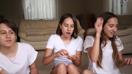 0:16 Teenager sisters girls triplet funny sit at home enjoy eat snacks potato chips throwing and catching Bilder und Videos suchen: gegenseitig