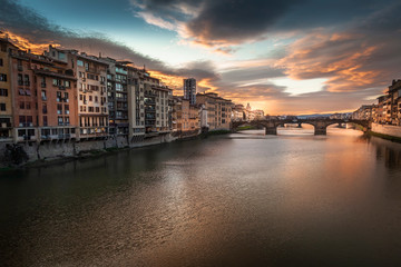 Fototapeta na wymiar The Ponte Vecchio is one of the symbols of the city of Florence and one of the most famous bridges in the world. Here an enchanting and soothing sunset on the river