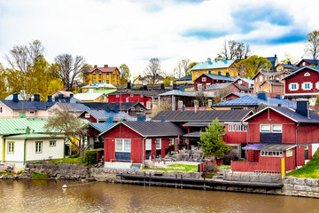 Fototapeta premium Scenic view of the Finnish city of Parvoo. Neat outbuildings. Spring nature. Multicolored buildings along the city promenade.