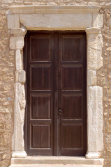 Fototapeta na wymiar The background old beige stony wall with door