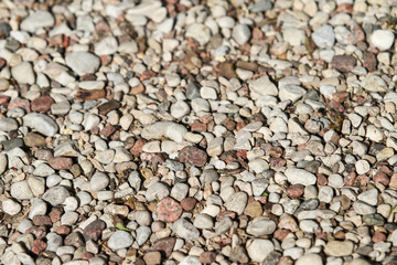 Background type view of small rocks on a pavement road. 